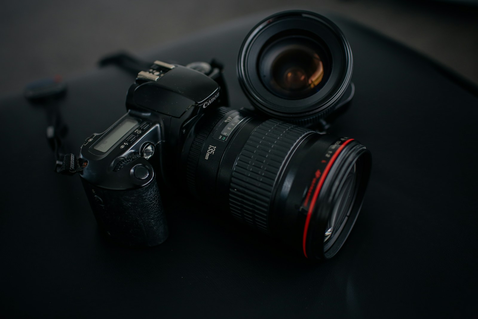 A cinema camera body and lens resting in low light