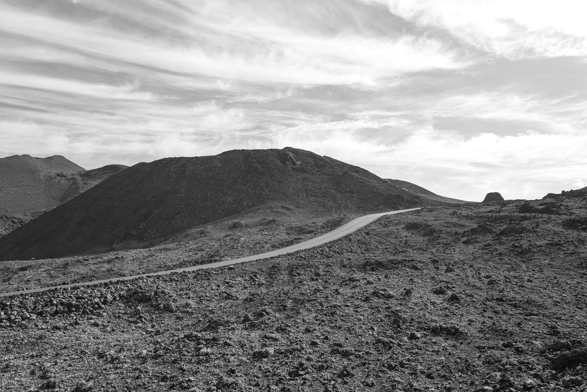 A lone road curving across an open volcanic landscape