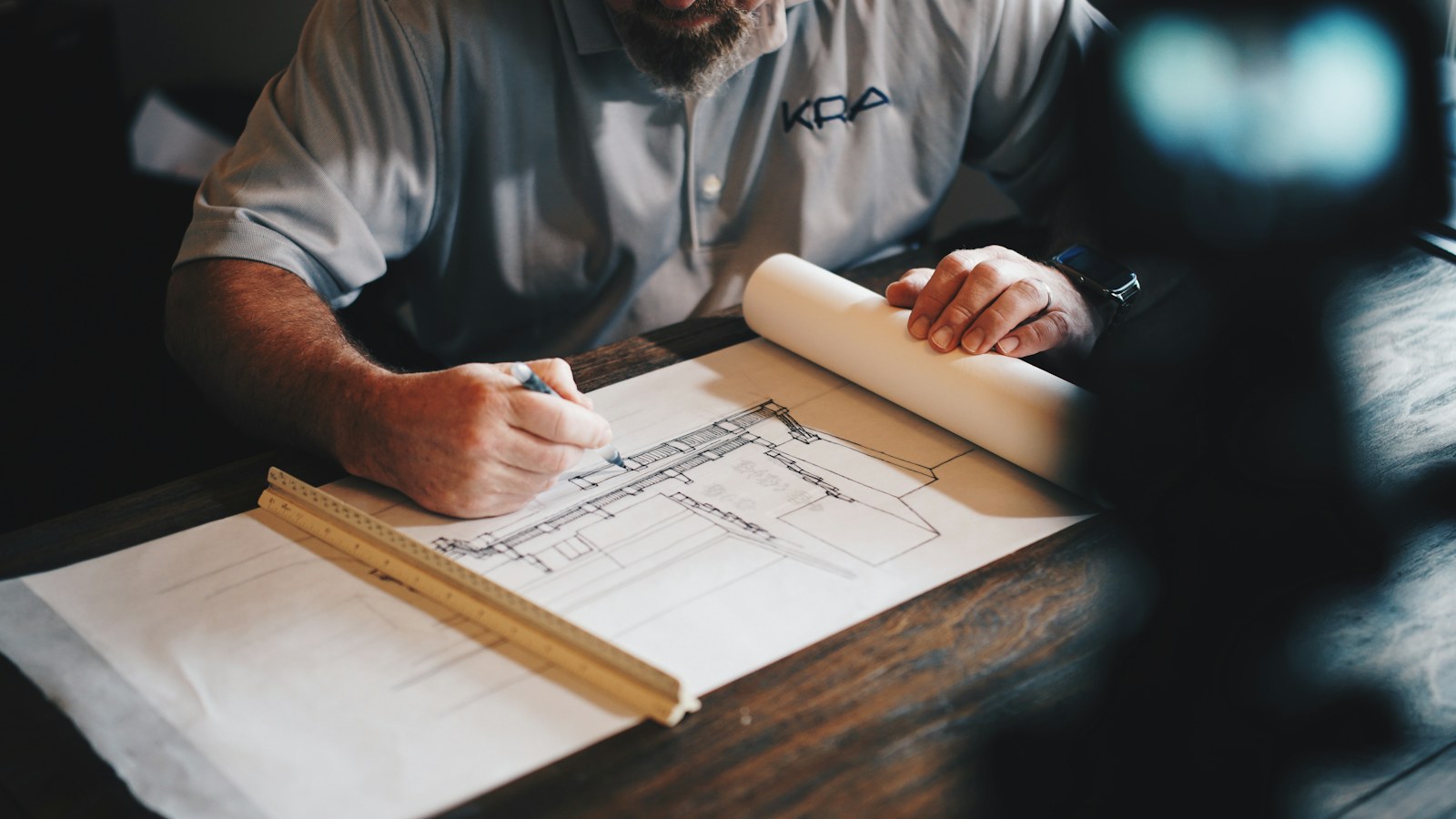 Hands drafting technical plans on paper