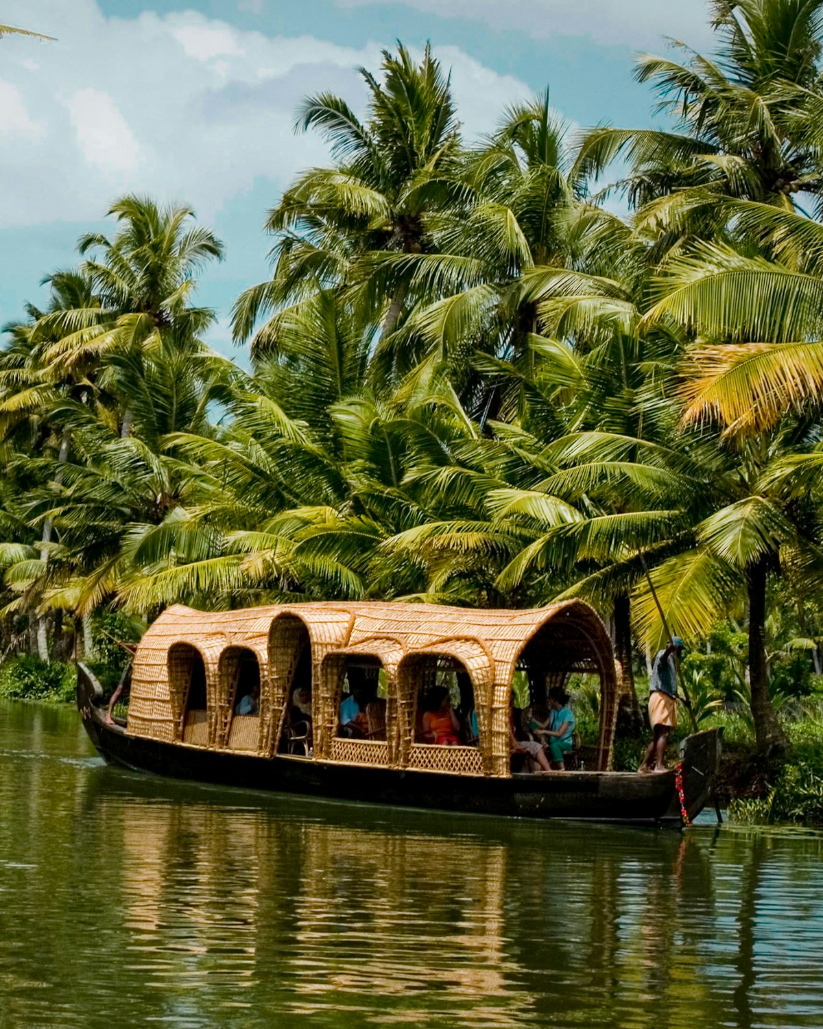 A Kerala houseboat on backwaters lined with coconut palms